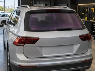 Película roxa e desbotada no vidro traseiro de um carro