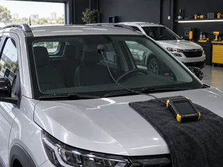 Para-brisa de um carro com medidor de transparência encostado no vidro