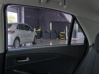 Película antiga descolando na borda do vidro de um carro