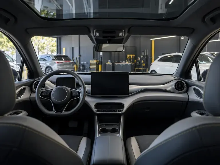 Painel de um carro elétrico com tela central, sensores e teto de vidro